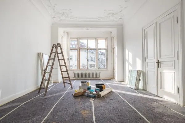 Même pièce avant rénovation : sols protégés, murs en préparation, échelle de chantier